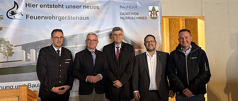 Fünf Personen vor einem Plakat