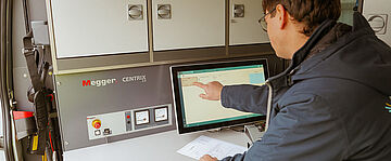 Techniker bedient Messgeräte im Kabelmesswagen