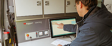 Techniker bedient Messgeräte im Kabelmesswagen