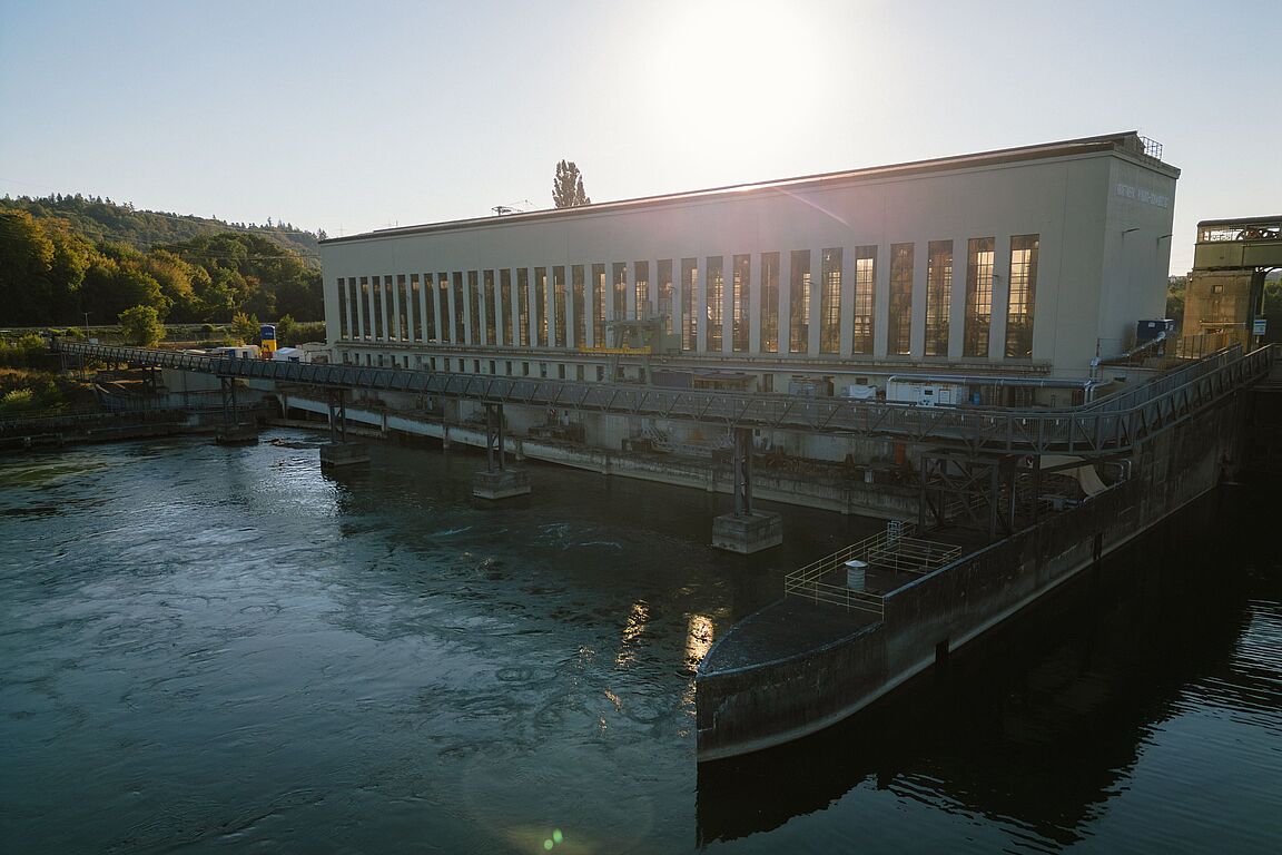 Wasserkraft für eine nachhaltige Energieversorgung Wasserkraftwerk an einem Fluss mit Maschinenhalle und Wehranlage.