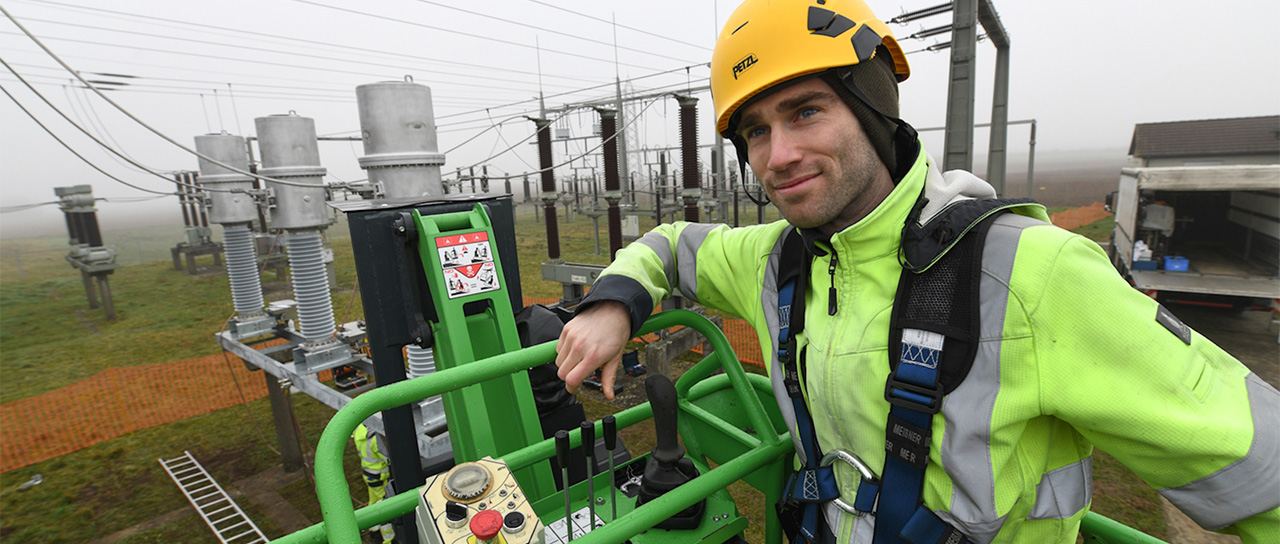 Monteur in Schutzausrüstung bei Arbeiten an Umspann- und Stromnetzen